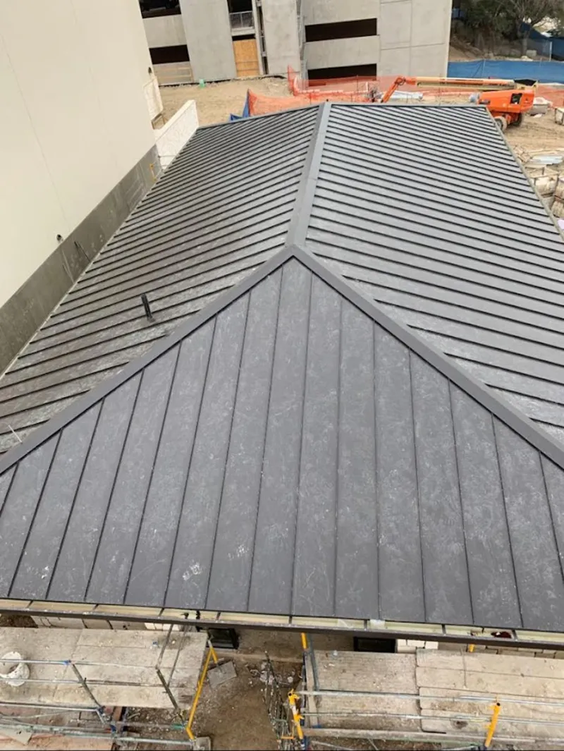 Commercial metal roof construction with crane equipment in Salem